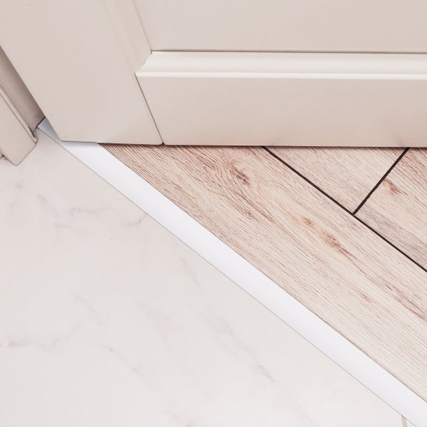 Detailansicht einer Übergangsschiene zwischen Fliesen und Laminat