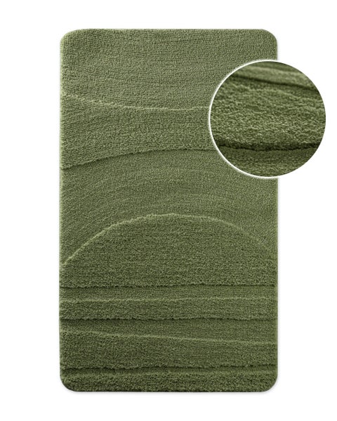 Grüner Badeteppich mit weichem Flor und geprägtem Linienmuster.