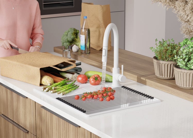 Küchenszene mit Gemüse, Wasserhahn und Spüle mit Abtropfgitter