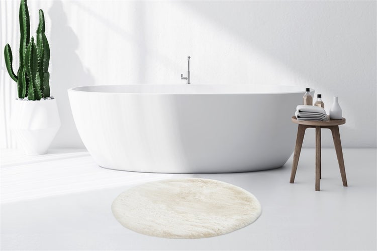 Runder Hochflor-Teppich in cremeweißer Felloptik mit weicher Oberfläche.
