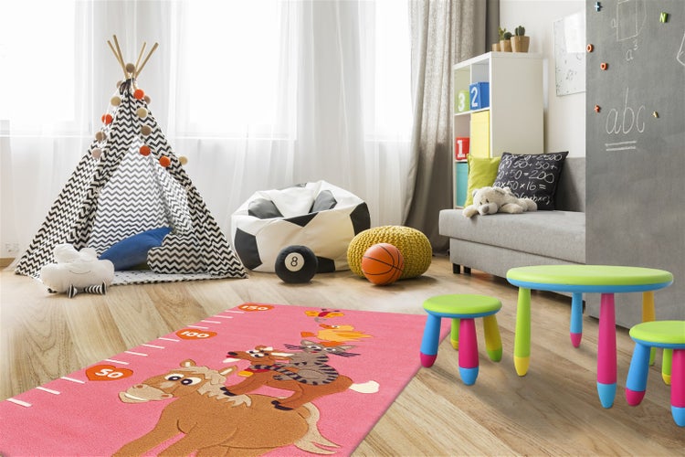 Hell eingerichtetes Kinderzimmer mit einem rosa Teppich mit Tiermotiven und Messskala, einem gemusterten Tipi und bunten Kindermöbeln.