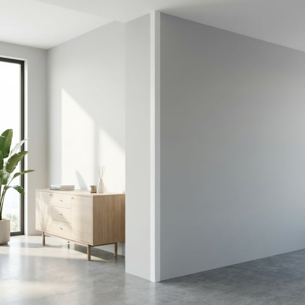 Heller moderner Wohnraum mit Holzkommode, Zimmerpflanze und bodentiefem Fenster auf Betonboden.