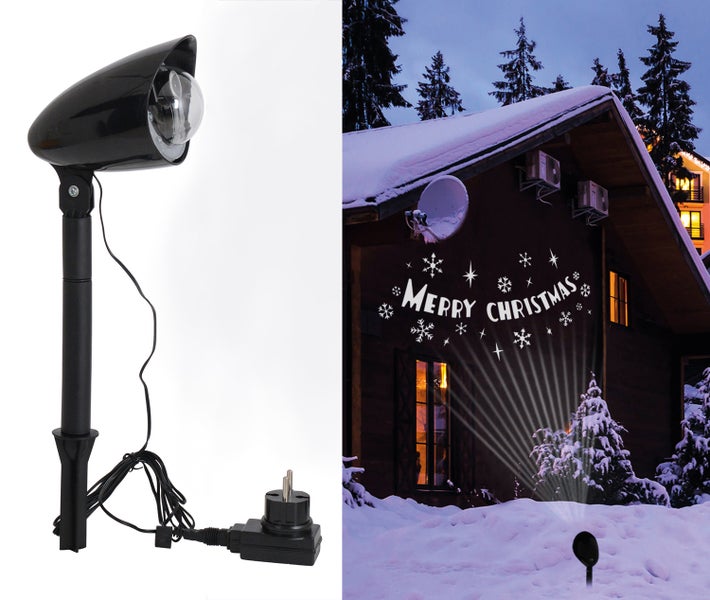 Dekorative Weihnachtsbeleuchtung mit Projektor und projiziertem Schriftzug 'Merry Christmas' an Hauswand