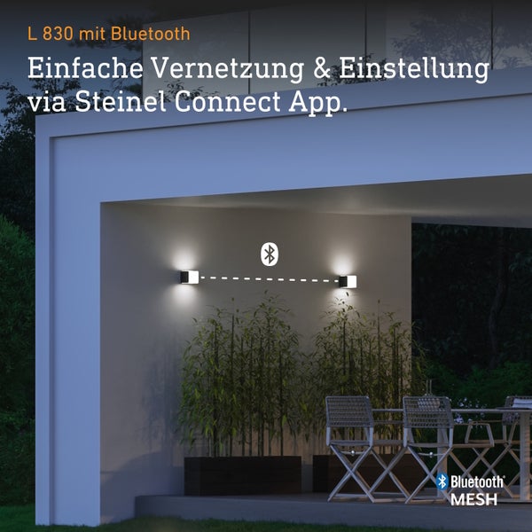 Zwei Steinel L 830 LED Außenwandleuchten mit Bluetooth Mesh Vernetzung auf einer Terrasse bei Nacht für App Steuerung.