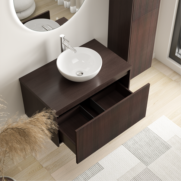 Moderner Waschtischunterschrank mit gerillter Front, Aufsatzwaschbecken und Einhebelmischer in einem Badezimmer mit rundem Spiegel.
