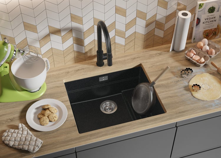 Küchenszene mit Spüle, Armatur, Küchenmaschine, Kochutensilien und Zutaten auf einer Arbeitsplatte.