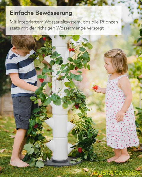 Kinder ernten Erdbeeren an einem weißen vertikalen Pflanzturm mit integriertem Bewässerungssystem im Garten. Gusta Garden Logo.