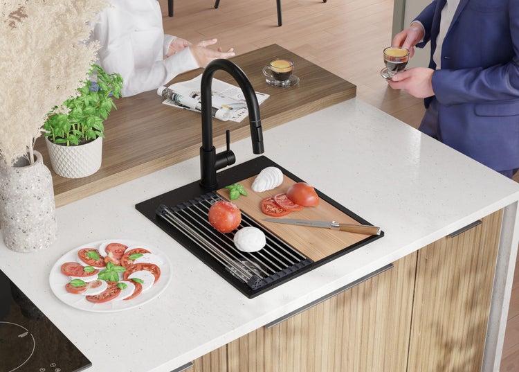 Küchenszene mit Spüle, Armatur, Schneidebrett, Tomaten, Mozzarella und Basilikum