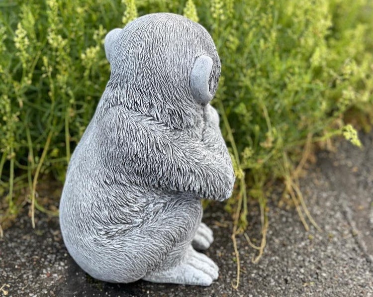 Steinfigur Affe als Gartendekoration in sitzender Haltung
