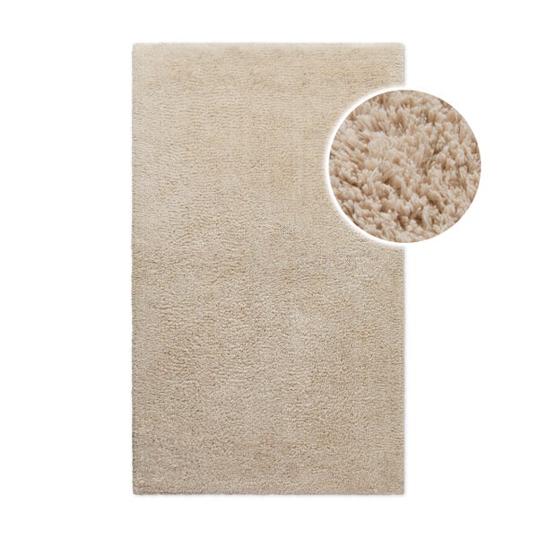 Rechteckiger Hochflor-Teppich in Beige mit weicher Oberfläche.