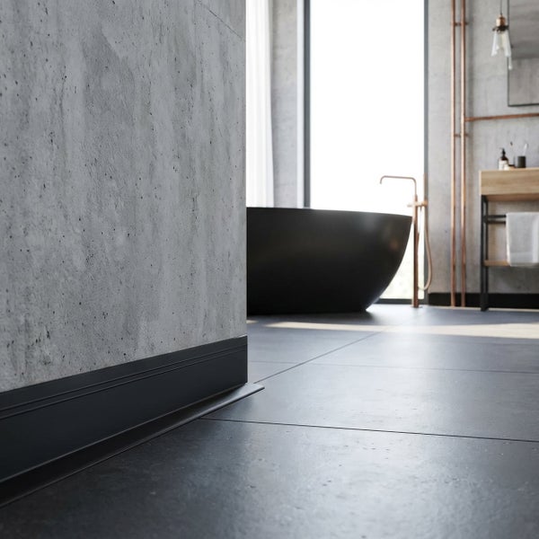 Moderne Sockelleiste montiert an einer Betonwand in einem Badezimmer mit Fliesenboden und einer freistehenden Badewanne.