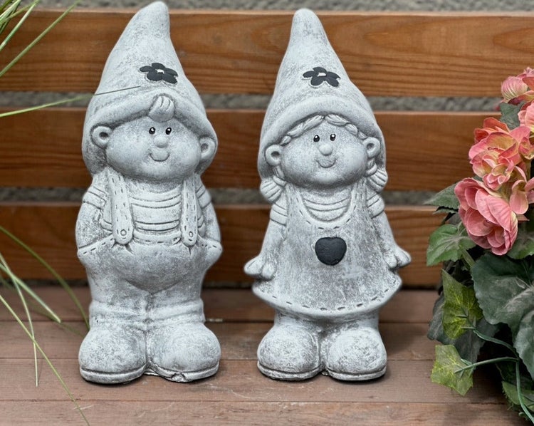 Zwei steinerne Gartenzwerge als Junge und Mädchen, detailreich gestaltet, ideal als dekorative Gartenfiguren.