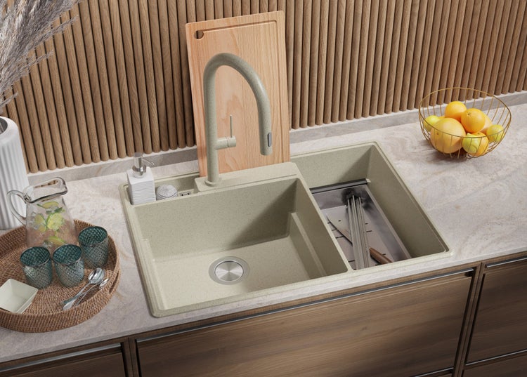 Küchenspüle mit Armatur, Spülmittelspender, Schneidebrett und Abtropfgestell in einer hellen Küche.