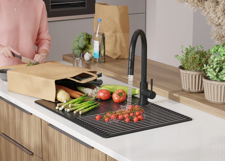 Spüle mit Abtropfgitter, Gemüse und Armatur in einer modernen Küche.