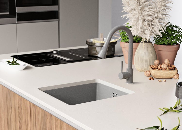 Küchenszene mit Spüle, Armatur, Kochfeld und Dekoration