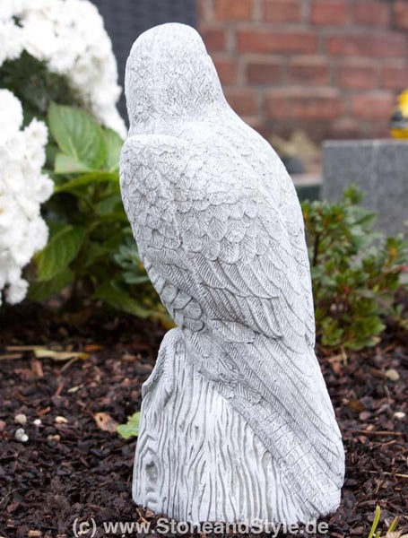 Steinfigur Eule auf einem Baumstumpf als wetterfeste Gartendekoration für den Außenbereich.