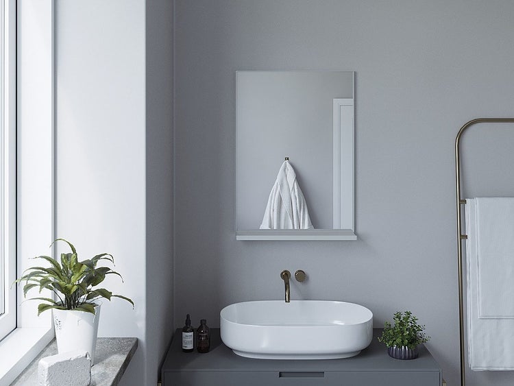 Modernes Badezimmer mit Waschtisch, ovalem Aufsatzwaschbecken, Wandarmatur und einem Wandspiegel mit Ablage über dem Waschplatz.