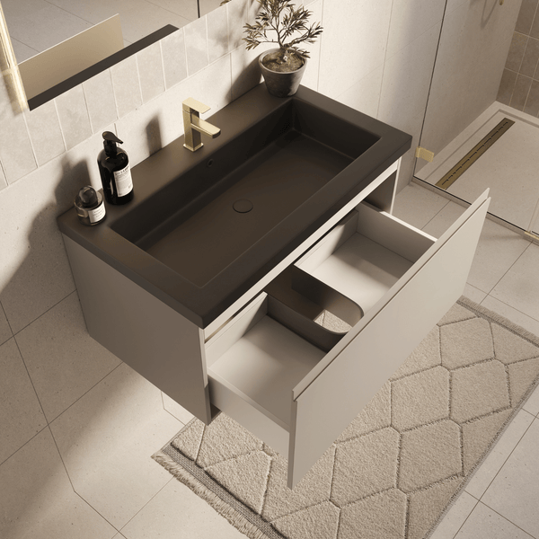 Moderner heller Bad-Waschtischunterschrank mit dunklem Waschbecken, goldener Armatur und einer geöffneten, organisierten Schublade.