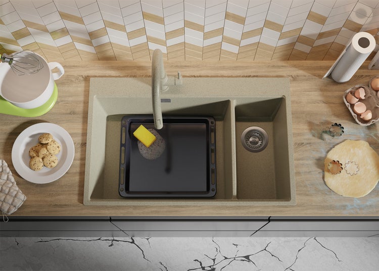 Küchenspüle mit Abtropffläche, Spülbeckenarmatur, Backblech und Küchenutensilien auf einer Küchentheke.