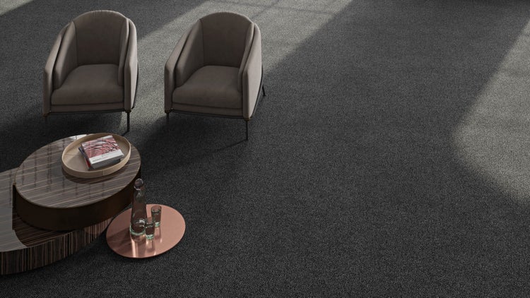 Dunkelgrauer Teppichboden in einem modern eingerichteten Wohnzimmer mit zwei Sesseln und einem Couchtisch.