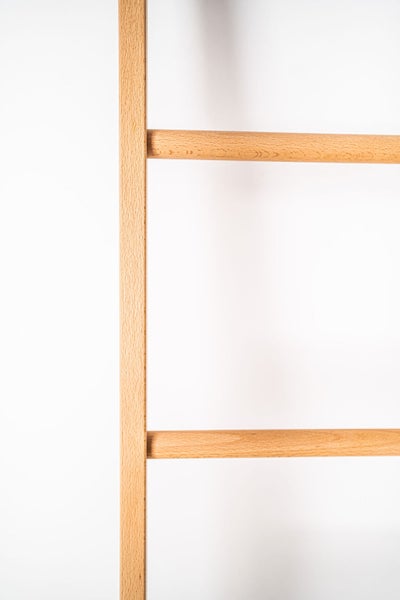 Detail einer Holzleiter aus Buche mit runden Sprossen und eckigem Seitenholm.
