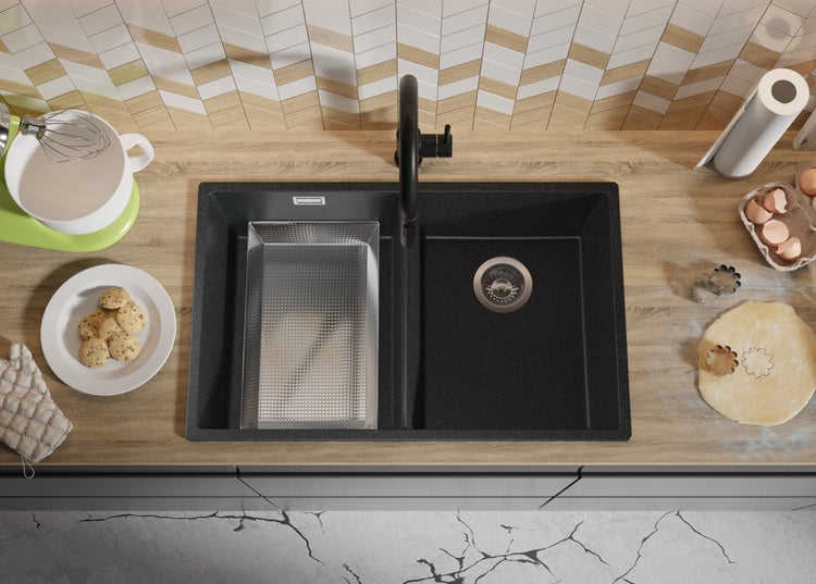 Spüle aus schwarzem Granit mit Abtropfschale in einer Küche mit Backutensilien