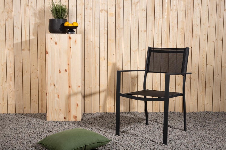 Szene mit einem Gartenstuhl, einem Holzhocker, einem Kissen und Dekoration