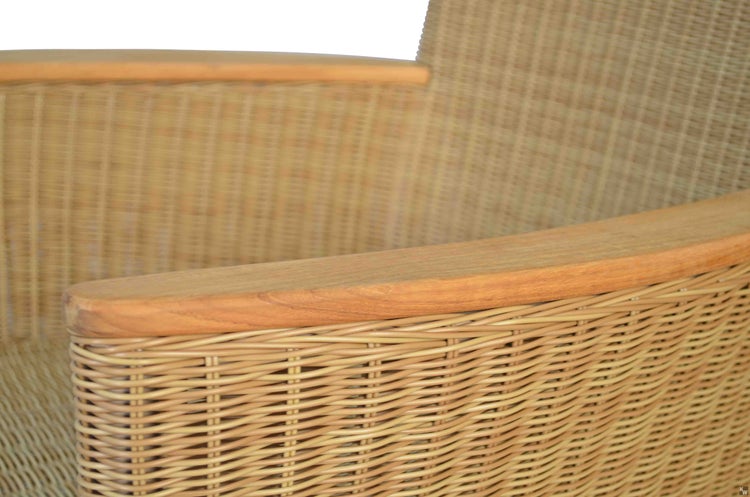 Detailansicht eines Rattansessels mit Metallfüßen.