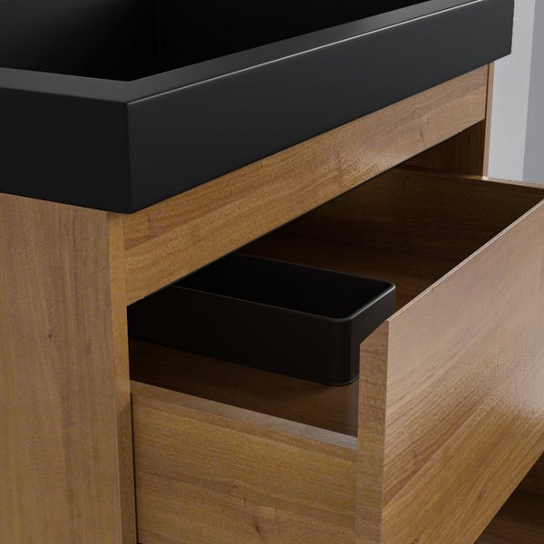 Nahaufnahme eines Waschbeckenunterschranks in Holzoptik mit einem schwarzen Waschbecken und einer geöffneten Schublade.