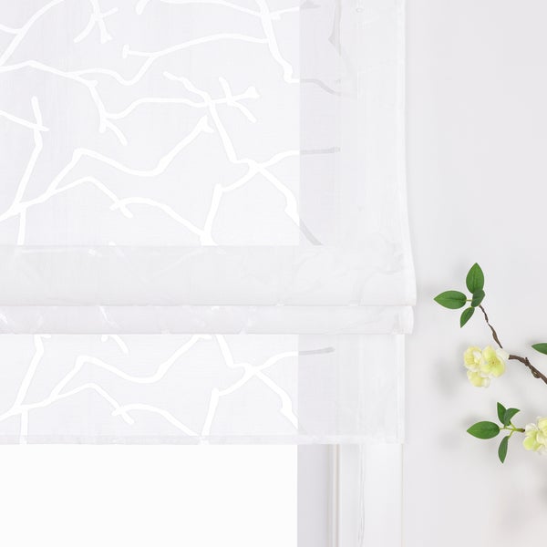 Weiße Fensterdekoration mit Muster und Blumenarrangement
