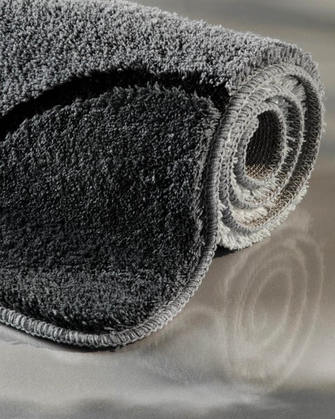 Gerollter Badteppich mit weichem Hochflor und geketteltem Rand.