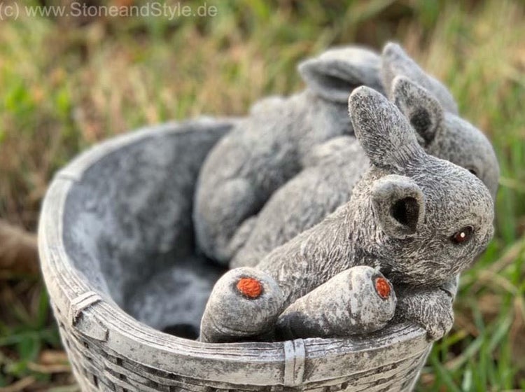 Steinfigur aus Steinguss in Form eines Korbes mit zwei Kaninchen als Gartendekoration für den Außenbereich.