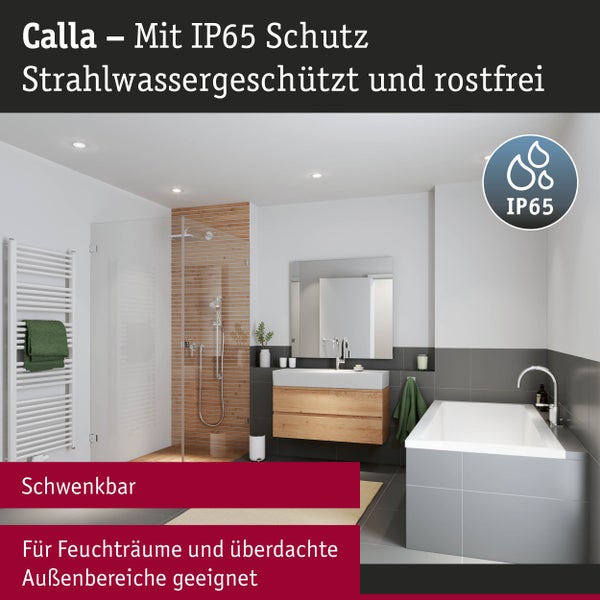 Modernes Badezimmer mit schwarzer Deckenleuchte, rundem Spiegel und Handtuchleiter.
