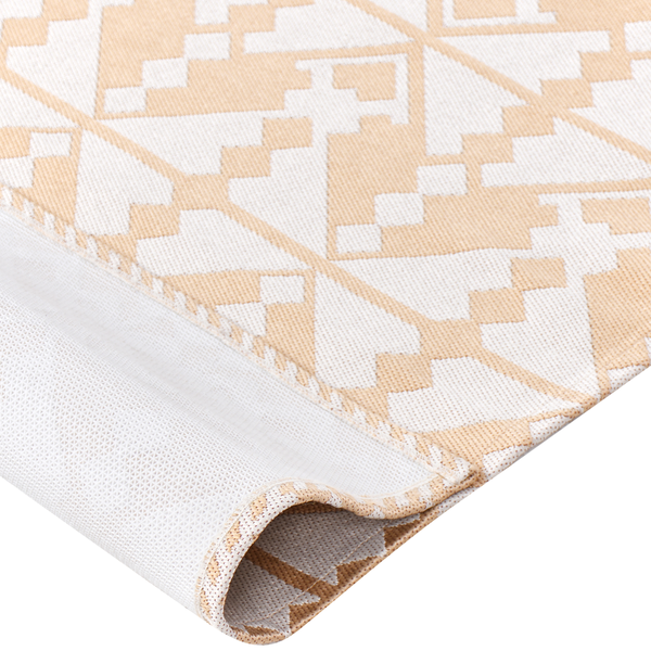 Nahaufnahme eines Teppichs mit geometrischem Muster und rutschfester Rückseite, eine Ecke ist umgeschlagen.