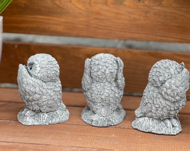 Drei Eulenfiguren aus Steinguss für die Gartendekoration, sitzend in verschiedenen Posen.