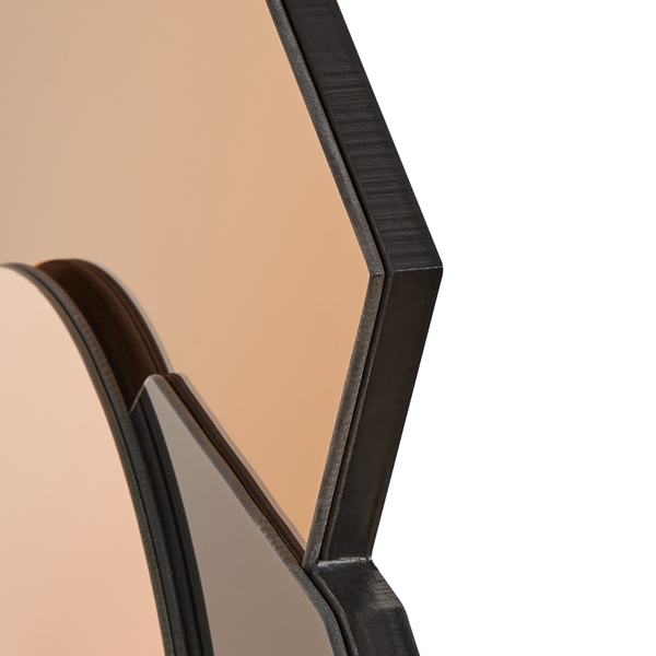 Detailaufnahme eines Spiegels mit einem dunklen Rahmen.