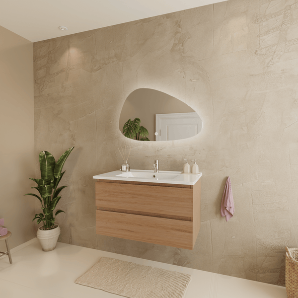 Modernes Badezimmer mit hängendem Waschtisch in Eiche-Optik, weißem Waschbecken und einem hinterleuchteten Spiegel in organischer Form.