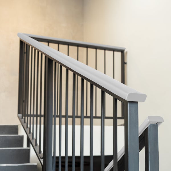 Modernes Treppengeländer aus Metall mit senkrechten Stäben und hellem Handlauf.