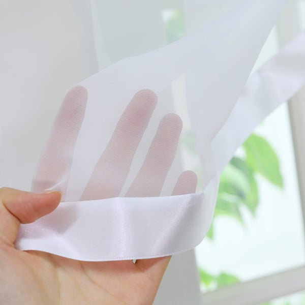 Detailaufnahme eines transparenten Vorhangs mit Hand im Vordergrund