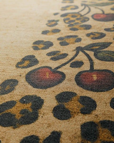 Nahaufnahme einer Kokos-Fußmatte mit Leopardenmuster und Kirsch-Motiv.