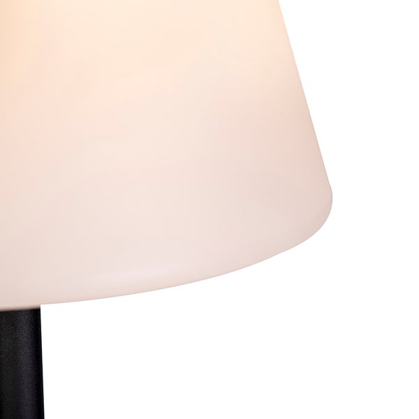 Detailansicht einer Lampe mit konischem, lichtdurchlässigem Schirm und einem dunklen Metallstativ.