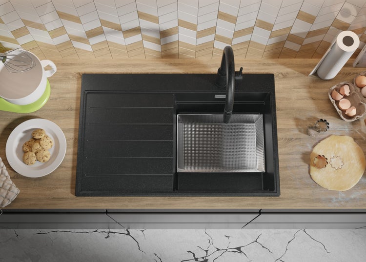 Küchenszene mit Spüle, Armatur und Backutensilien auf einer Küchentheke.