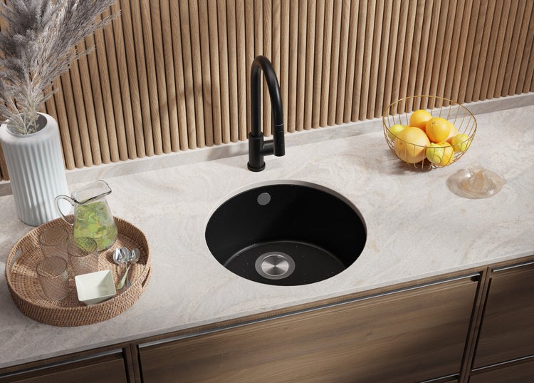 Küchenspüle mit Armatur, umgeben von Accessoires auf einer Küchentheke.