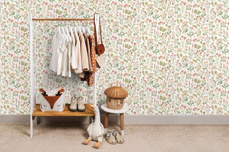 Kinderzimmer mit Kleiderständer, Spielzeug und Blumentapete.