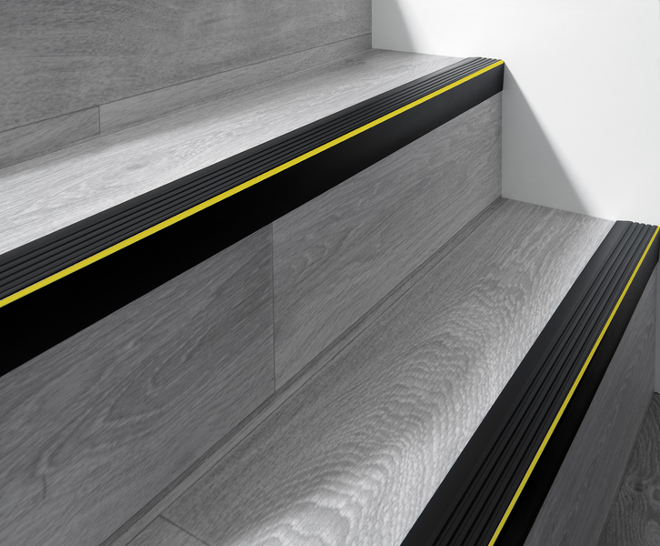 Treppe mit schwarzer Treppenkante und gelbem Streifen für erhöhte Sicherheit
