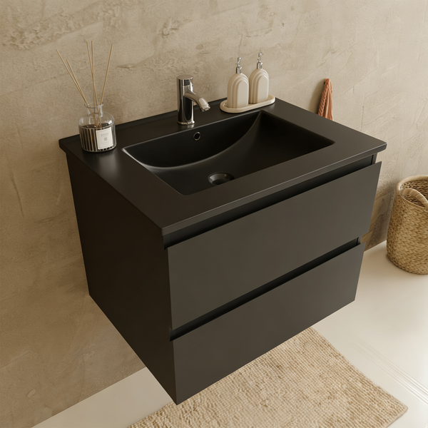Wandhängender Waschtischunterschrank mit zwei Schubladen, integriertem Waschbecken und Armatur aus Chrom in einem Badezimmer mit Steinwand.