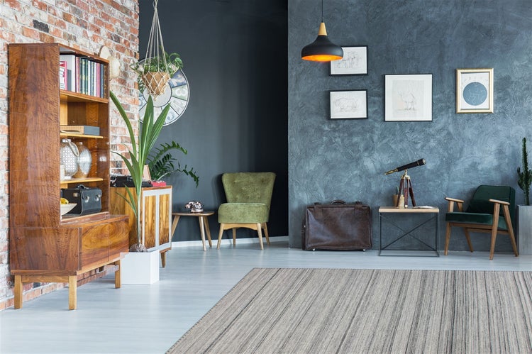Wohnzimmer mit gestreiftem Teppich, Holzmöbeln, Backsteinwand und blau strukturierter Wand im Vintage-Stil.
