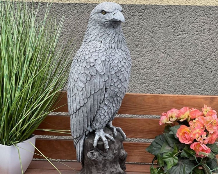 Gartenfigur Adler aus Steinguss, auf einem Ast sitzend, für die Dekoration im Garten oder auf der Terrasse.