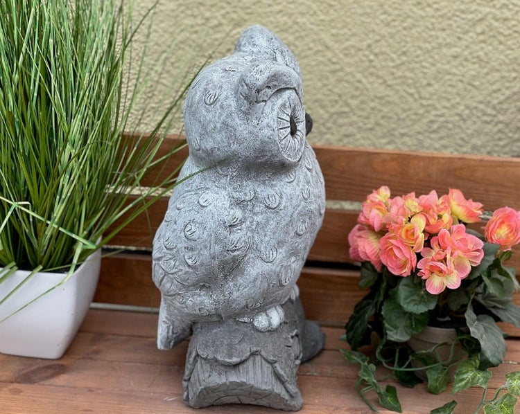 Gartenfigur Eule aus Stein auf einem Baumstamm, dekorative Steinguss-Figur für den Außenbereich.