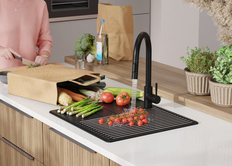 Küchenszene mit Spüle, Armatur und Gemüse zum Waschen und Zubereiten.